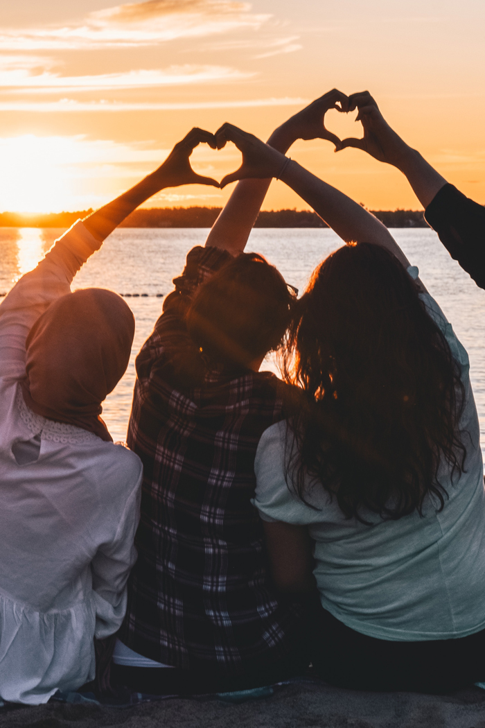 Gruppe aus Freund*innen vor einem Sonnenuntergang. Ein Klick auf das Bild öffnet eine Auswahl an Veranstaltungen mit inklusivem Angebot.